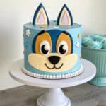 decorated bluey birthday cake on white cake stand