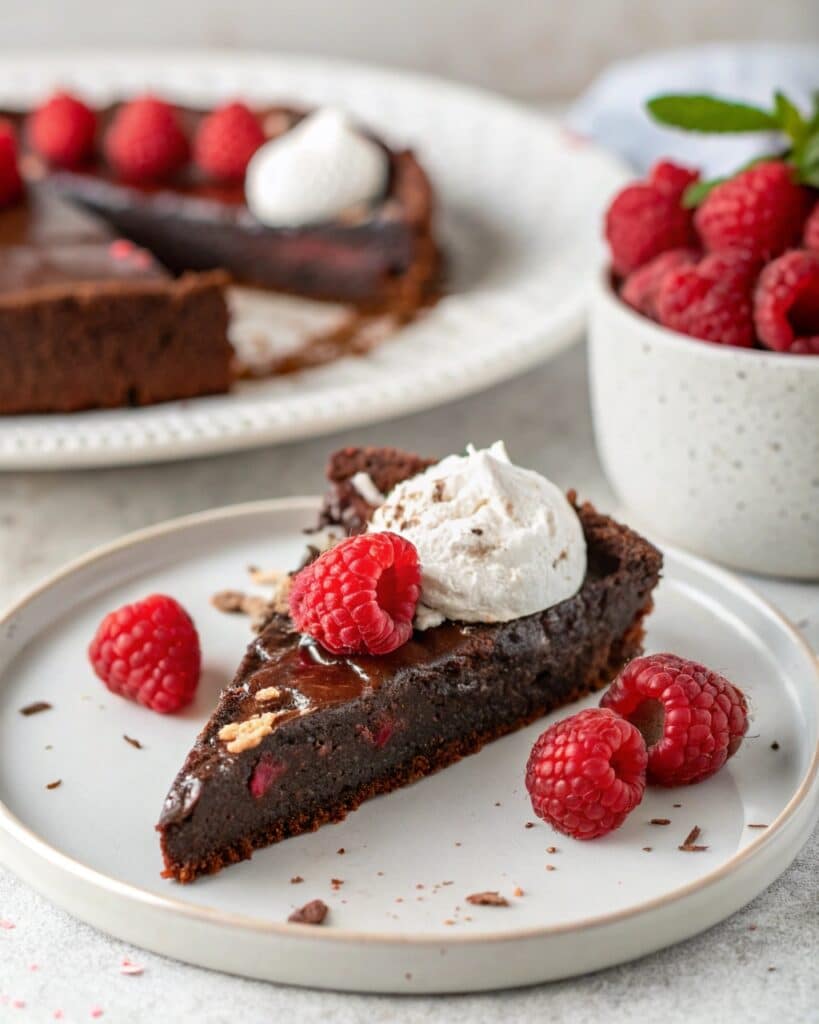 Slice of vegan flourless chocolate cake served