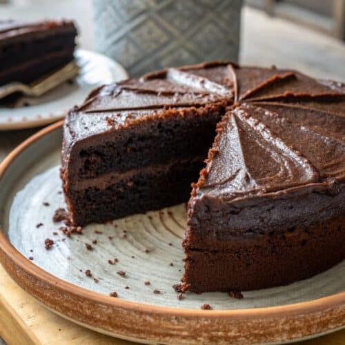 sliced black cocoa cake with glossy black cocoa buttercream
