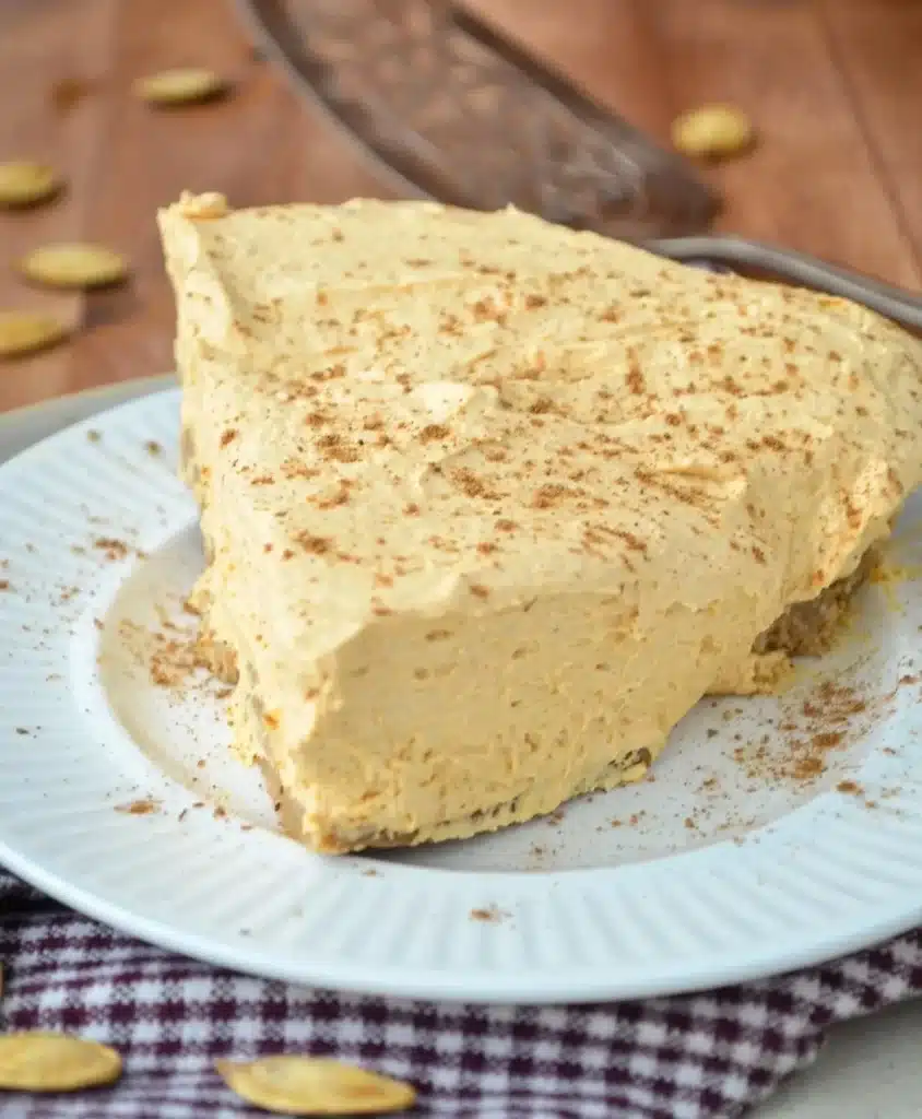 Delicious Pumpkin Fluff Pie slice topped with whipped cream and pumpkin spice